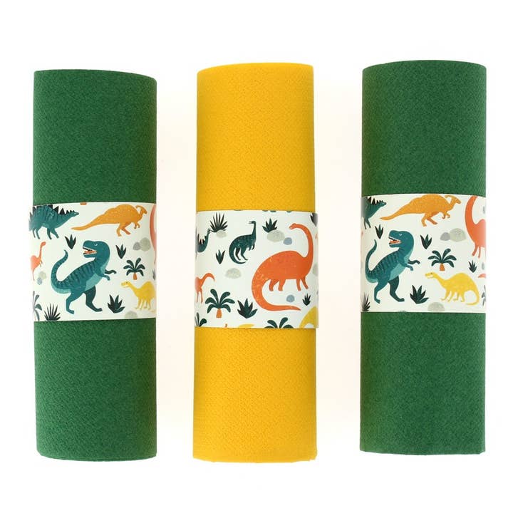 Serviettenringe mit Dinosaurier-Motiven, aufgerollte grüne und gelbe Servietten